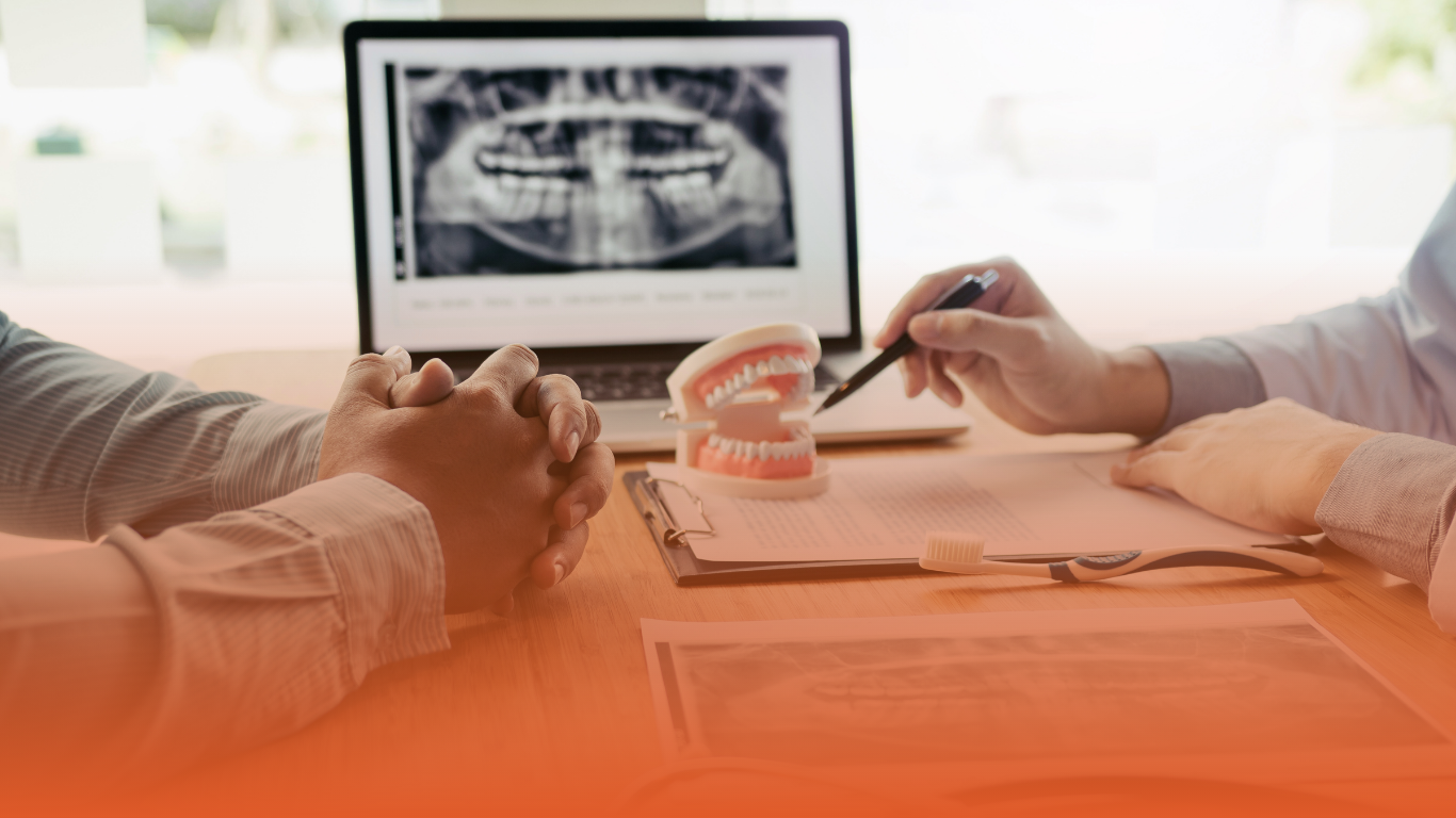 densura-blog-banner-does-professional-indemnity-cover-your-legal-representation-for-GDC-hearings Banner image of a dentist discussing paperwork: used in a blog about GDC hearings.